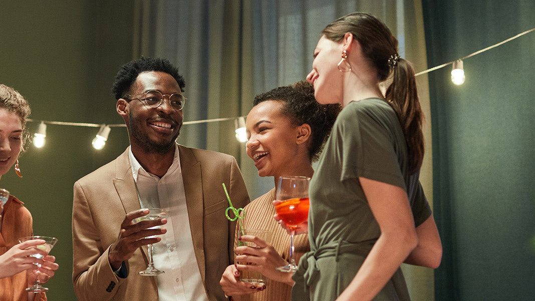 Five people standing in a living room holding cocktails