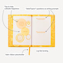 Happiness Prompted Journal features questions as writing prompts, quotes for inspiration, lay-flat binding, and a satin ribbon placeholder.