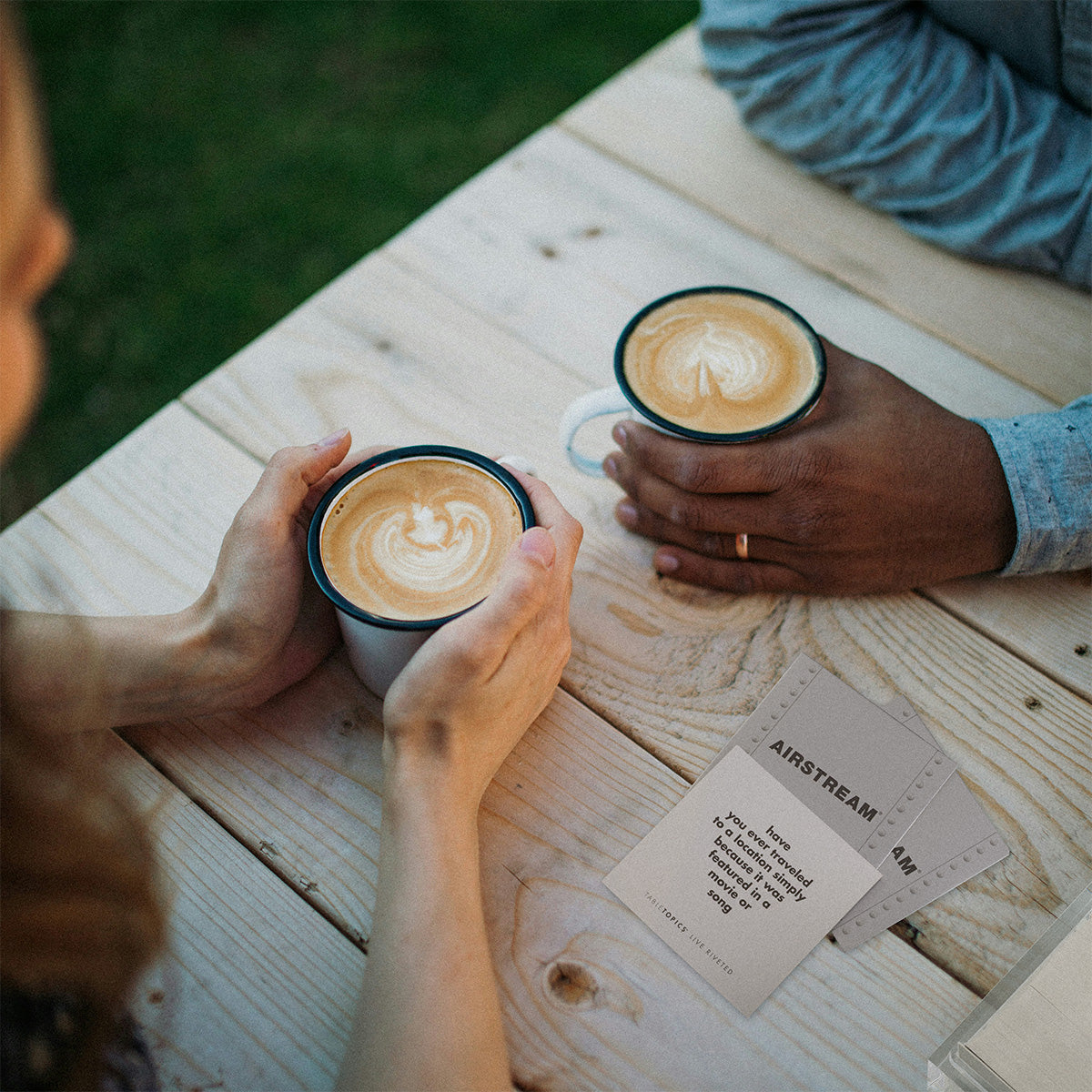 Couple having coffee with TableTopics Airstream Live Riveted Conversation Cards