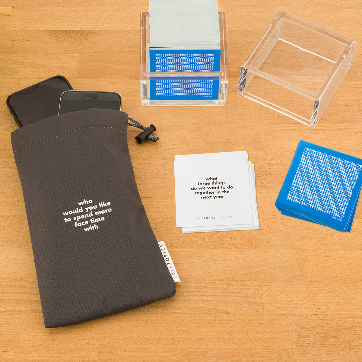 TableTopics Couples Conversation Starter Set and Phone Away Bag with phones in it on a table