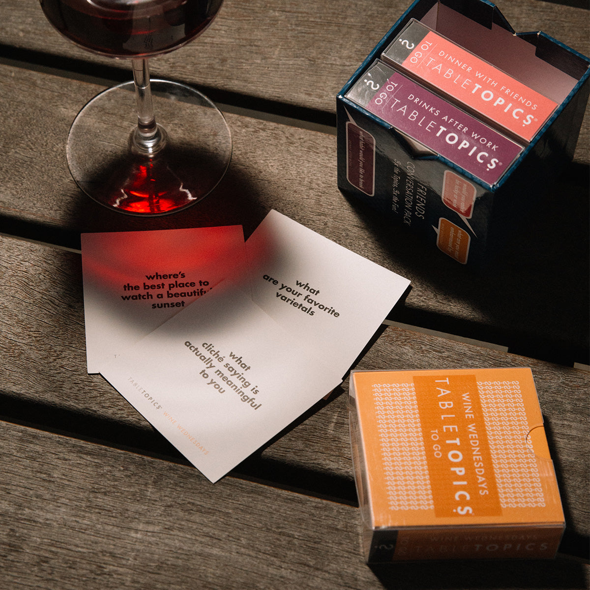TableTopics Friends Conversation Pack on a table next to wine and three cards sitting out