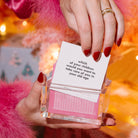 A woman's hand pulling a card out of the TableTopics Girls Night Out conversation starter box