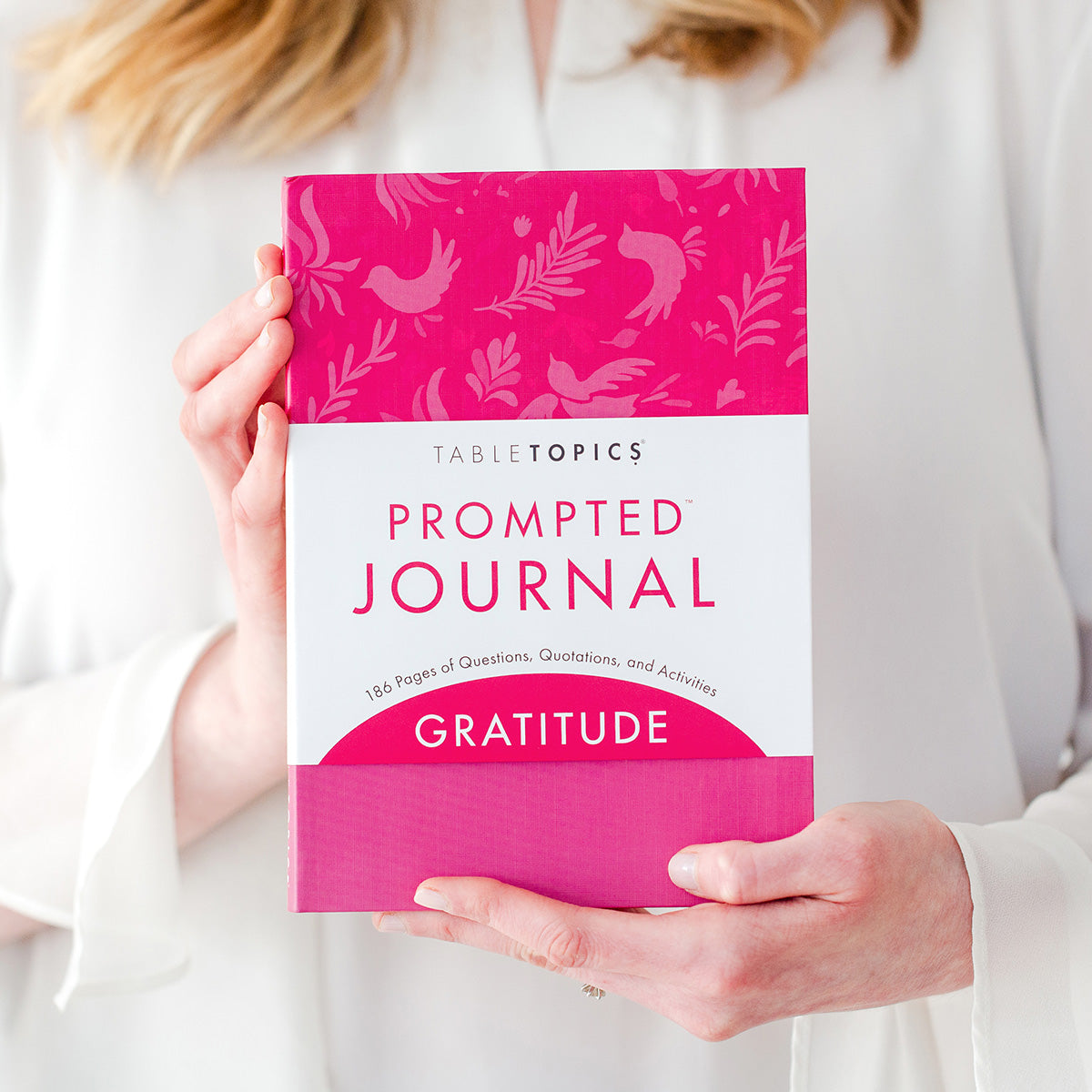 Woman holding TableTopics Gratitude Prompted Journal