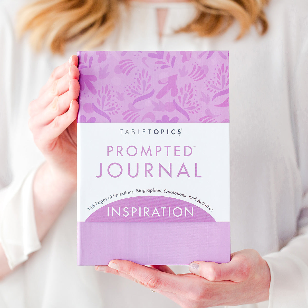 Woman holding TableTopics Inspiration Prompted Journal