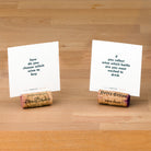 Two wine corks holding up two TableTopics Savor conversation cards