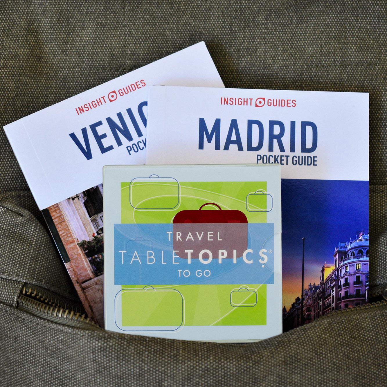TableTopics Travel To Go conversation card set with two travel guides in a backpack pocket