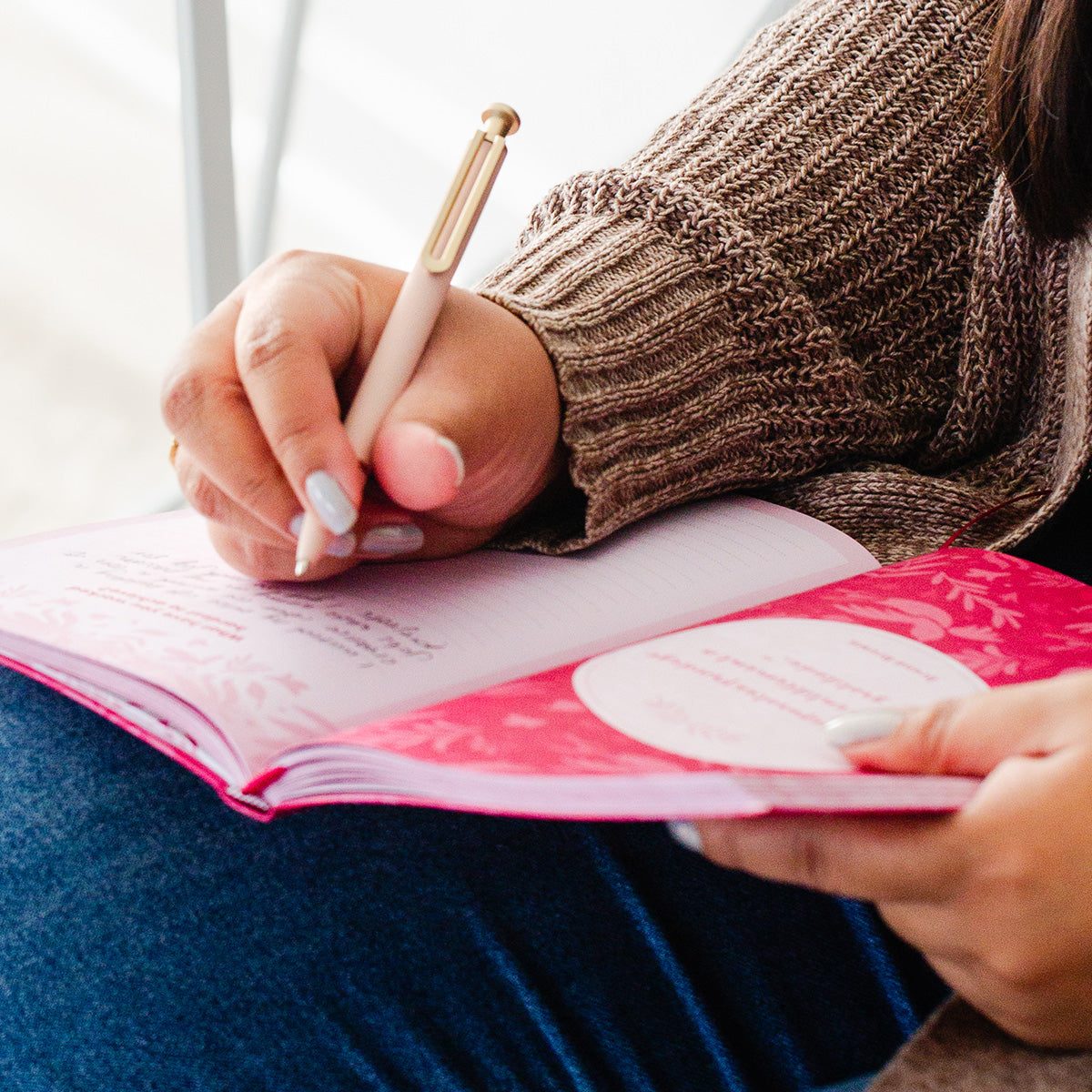 Woman writing in TableTopics Gratitude Prompted Journal
