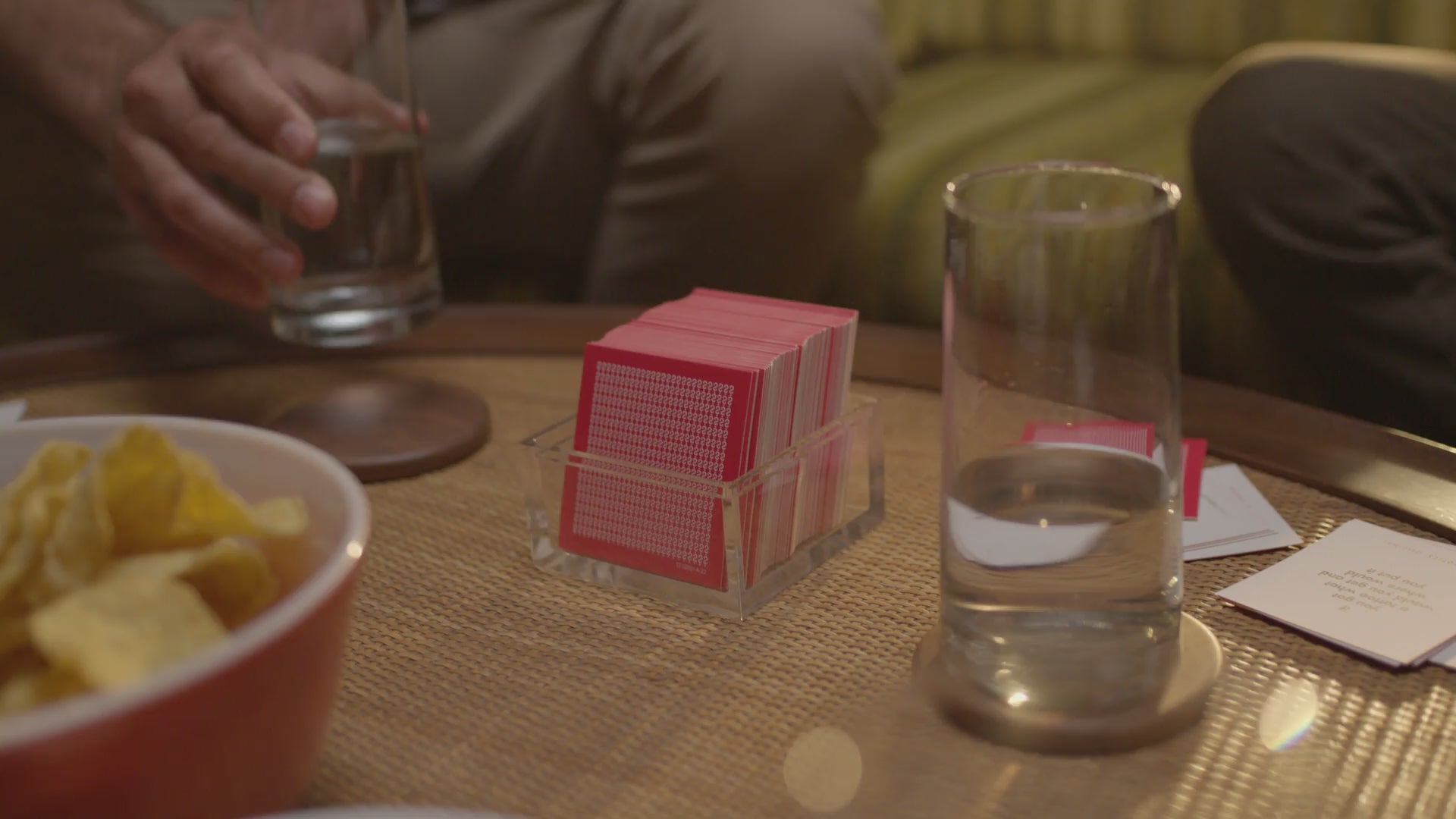 Friends playing TableTopics Original in living room, family playing Family at the dinner table, and a couple playing Couples on the couch