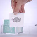 Hand pulling out TableTopics Teen conversation cards from the container and showing the questions
