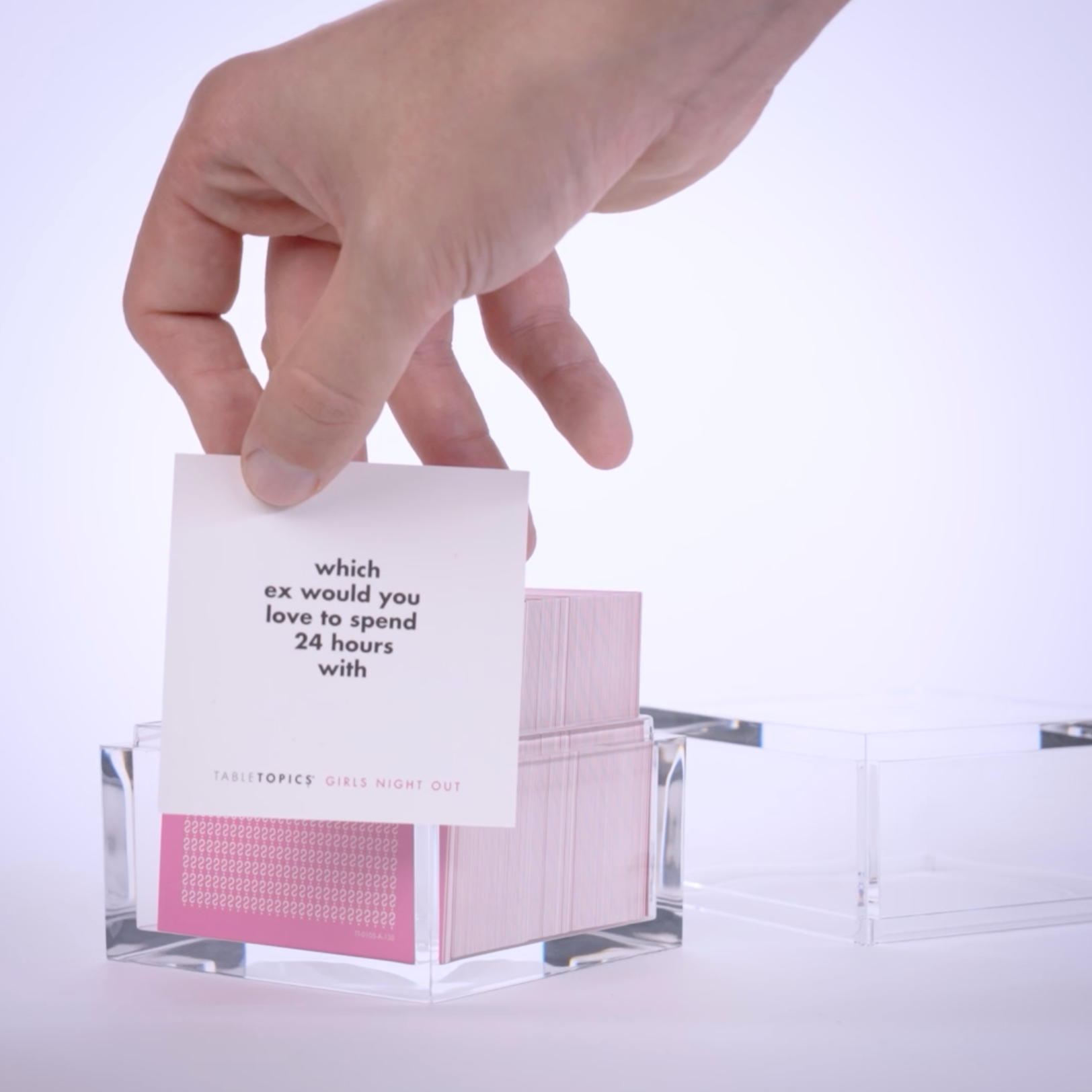 Hand pulling conversation cards from TableTopics Girls Night Out and showing the questions