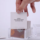 Hand pulling out TableTopics Not Your Mom's Dinner Party cards from the container and showing the questions