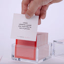 Hand pulling out TableTopics Original cards from the container and showing the questions