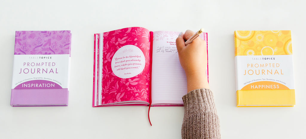 Writing in a prompted journals showing how to journal