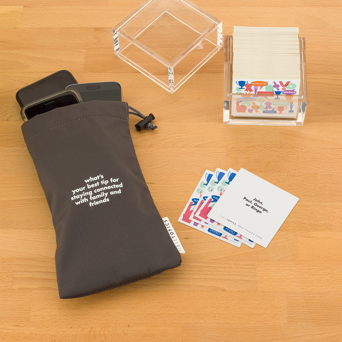 TableTopics Best Things Ever Conversation Starter Set and Phone Away Bag with phones in it on a table