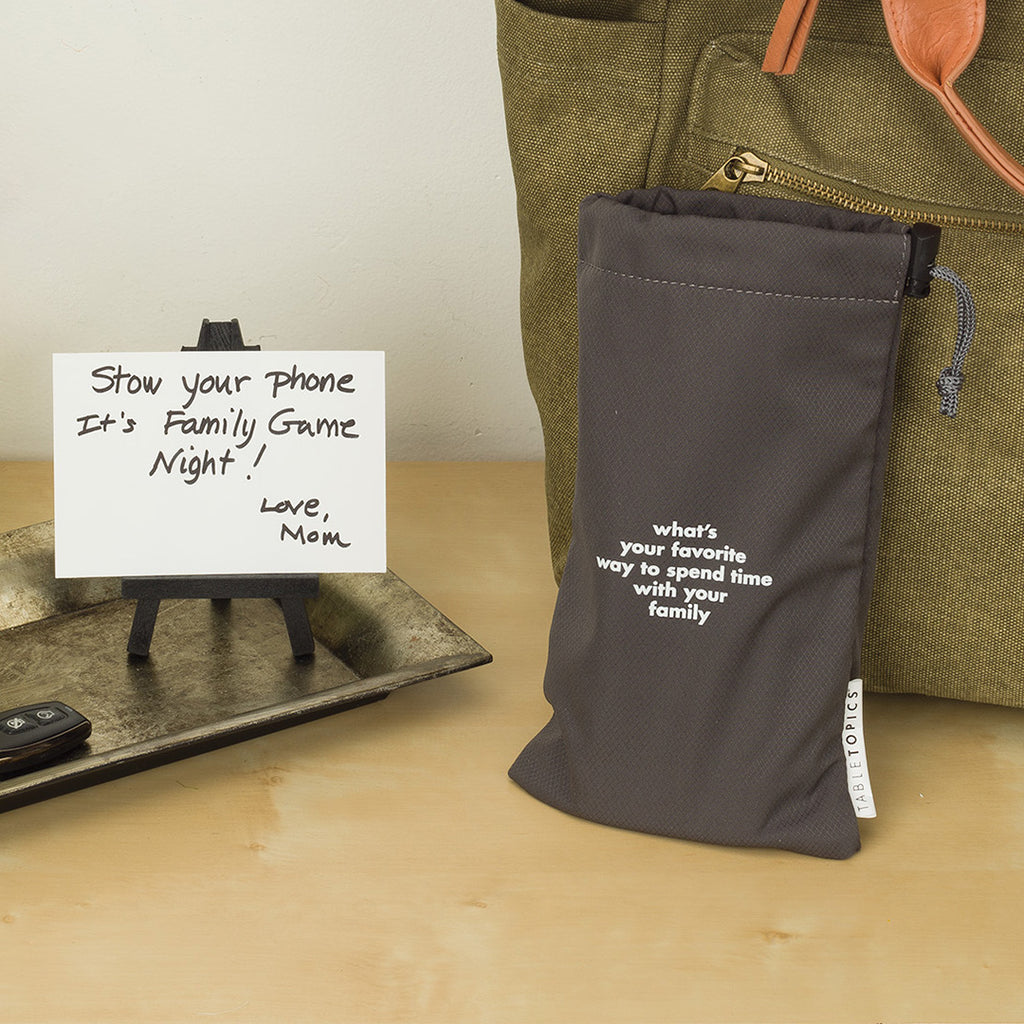 TableTopics Phone Away Bag on entry table with a note, "Stow your phone. It's Family Game Night!"