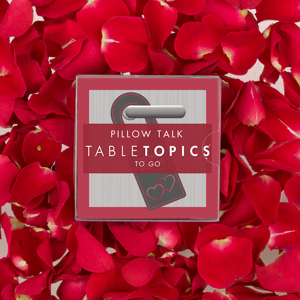 Romantic TableTopics Pillow Talk conversation card set for couples on top of a bed of rose petals