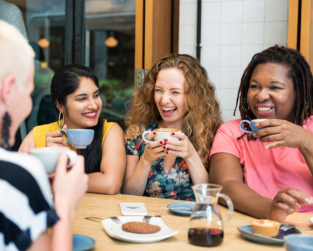 Women having coffee and playing with TableTopics: The App