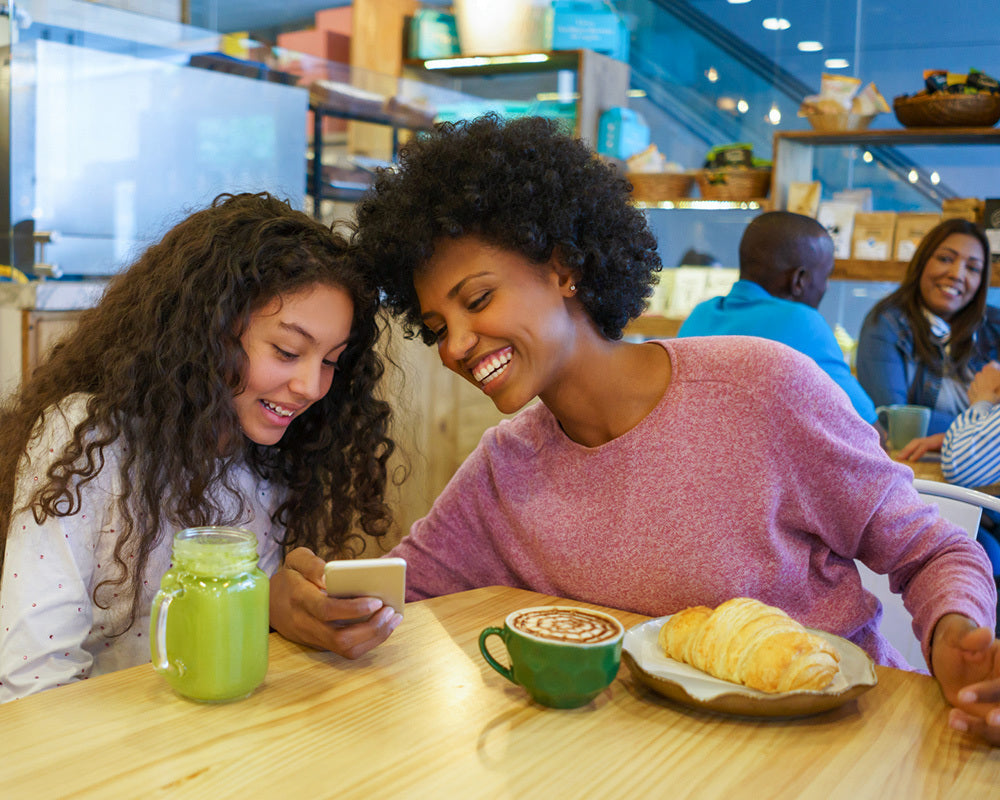 Mom and daughter using TableTopics: The App at a cafe