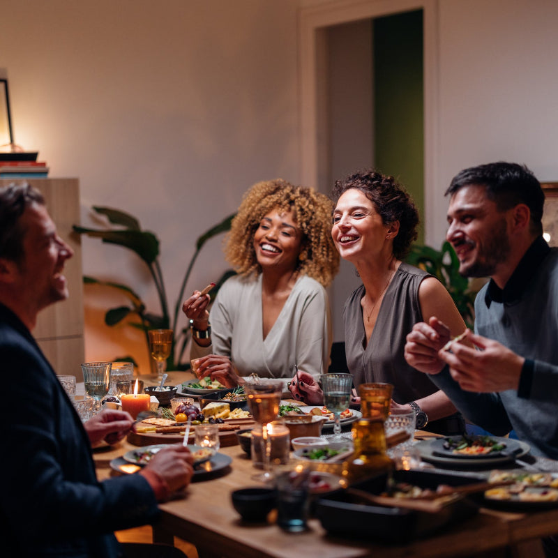 Group of people enjoying a meal together at a dinner party.