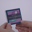Hand pulling out TableTopics Dating conversation cards from the container and showing the questions