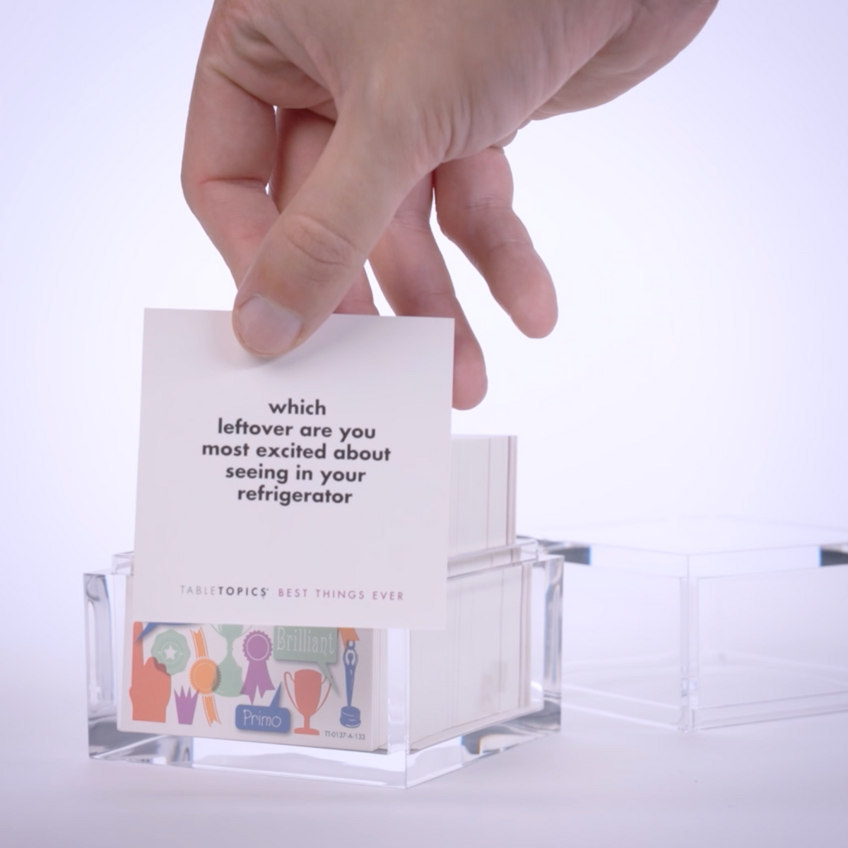 Hand pulling conversation cards from TableTopics Best Things Ever and showing the questions