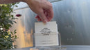 Hand pulling conversation cards out of TableTopics Airstream Live Riveted and showing questions.