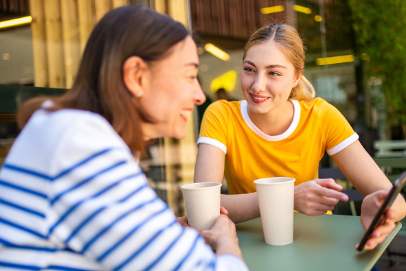 Mom and Daughter Using TableTopics: The App at a Cafe