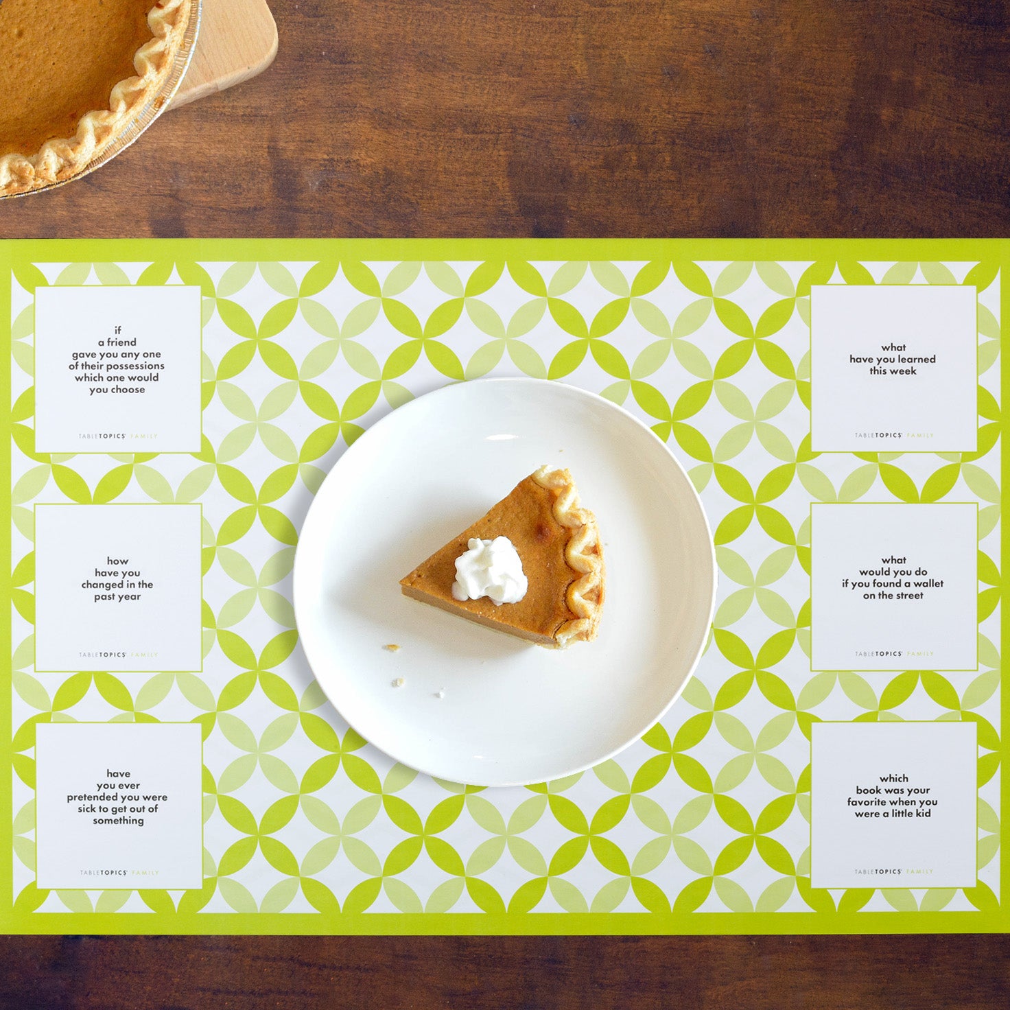 A slice of pie on a plate on a TableTopics Family Paper Placemat