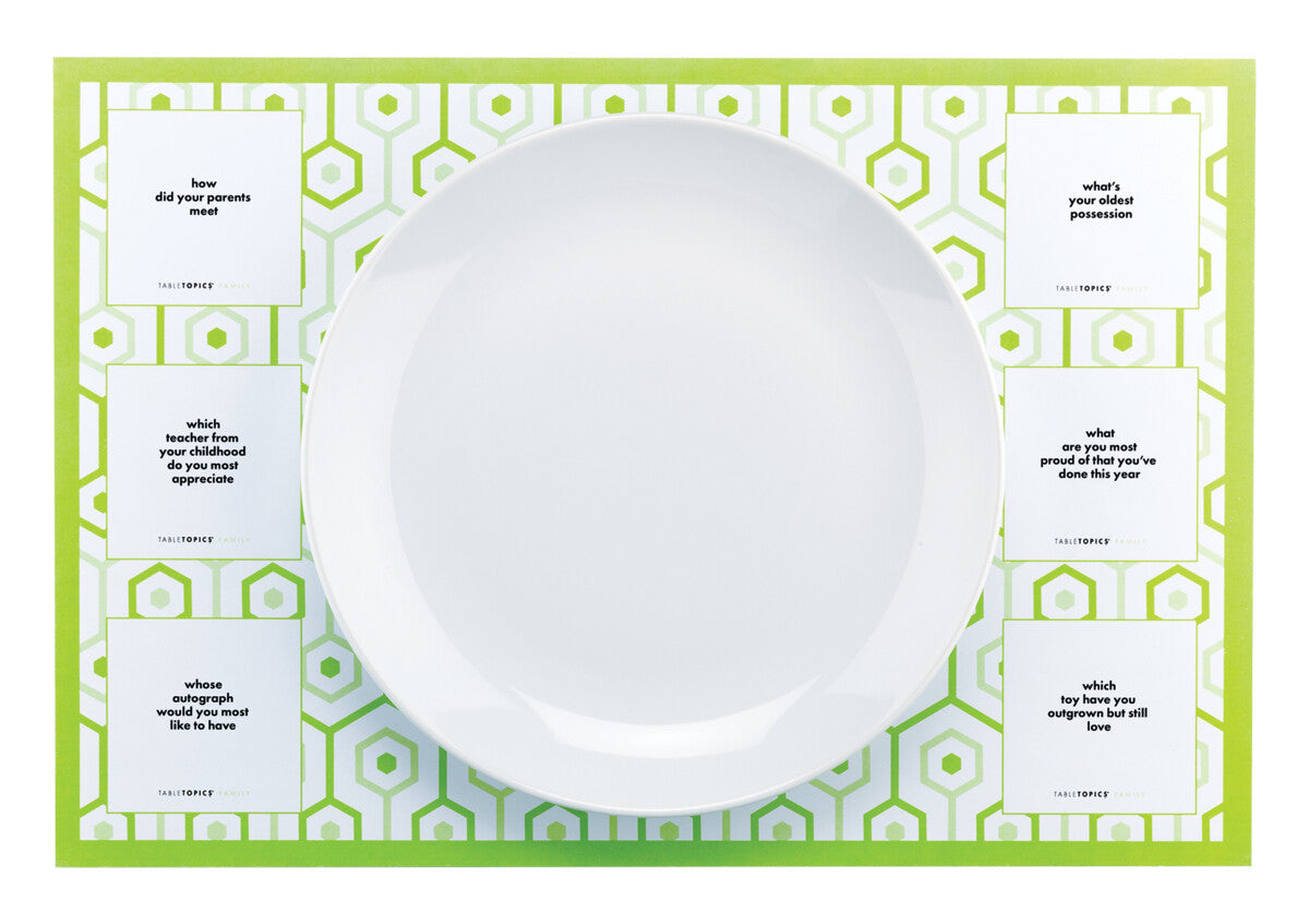 TableTopics Family Paper Placemat with a plate on top. 6 conversation starter questions are on the placemat.